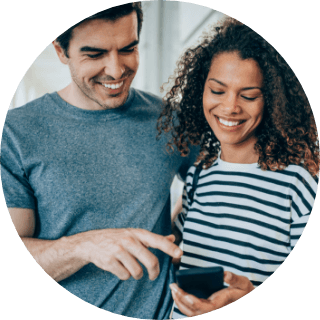 Persona sonriendo mientras mira un smartphone.